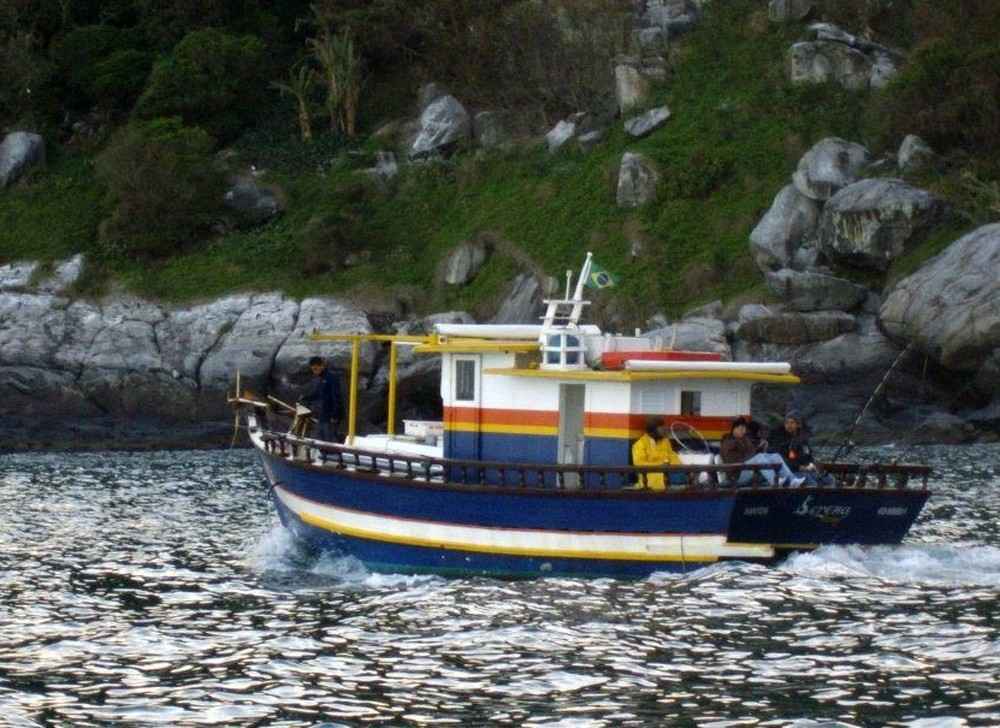 O vento forte e as ondas altas fizeram o barco adernar e virar. Os dez turistas e dois tripulantes foram lançados na água