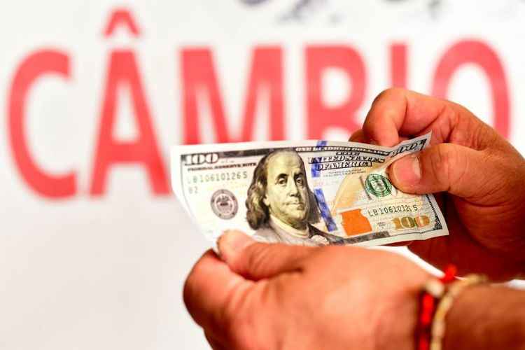 foto da nota de dólar, em frente da palavra 'câmbio'