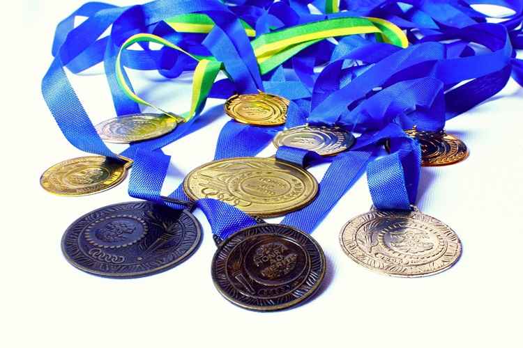 medalhas de bronze, ouro e prata com cordas coloridas como azuis e vermelhas em um fundo branco