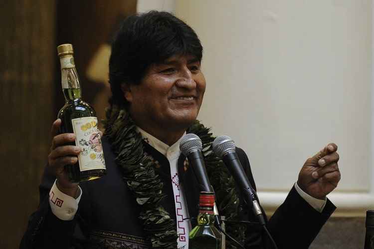 Bolivian President Evo Morales shows a bottle containing a coca-based drink during the ceremony to promulgate a government bill increasing the legal areas of cultivation of coca, at the Quemado presidential palace in La Paz, on March 8, 2017. Under the new law, the legal cultivation area for the country's two main coca-growing regions would be extended from 12,000 hectares to 22,000 -- capped at 14,300 hectares for the Los Yungas region and 7,700 hectares in the Chapare region, where Morales used to grow coca.