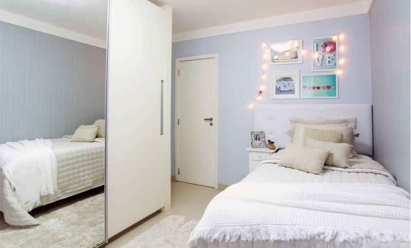 No quarto projetado por Gabriela De Rossi, as cores são todas neutras, em tons de branco e azul clarinho. Os objetos que se tornam mais marcantes seguem a mesma paleta de cores, porém em tons mais intensos. As lâmpadas diferentes também acrescentam personalidade ao espaço.