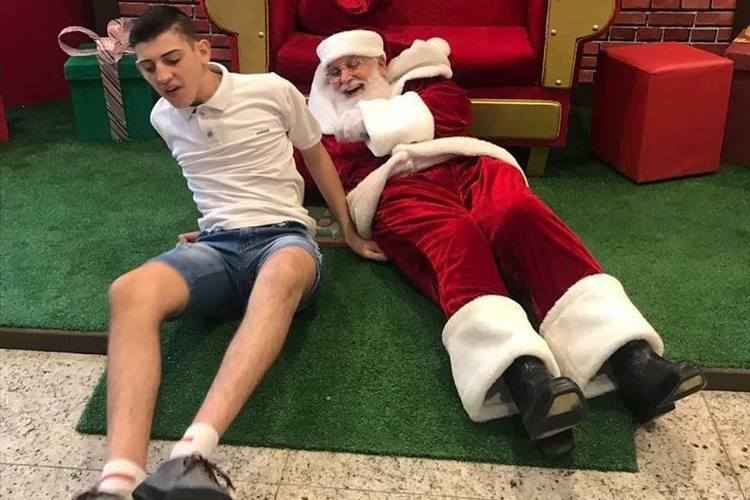 papai noel fofo com menino autista em shopping