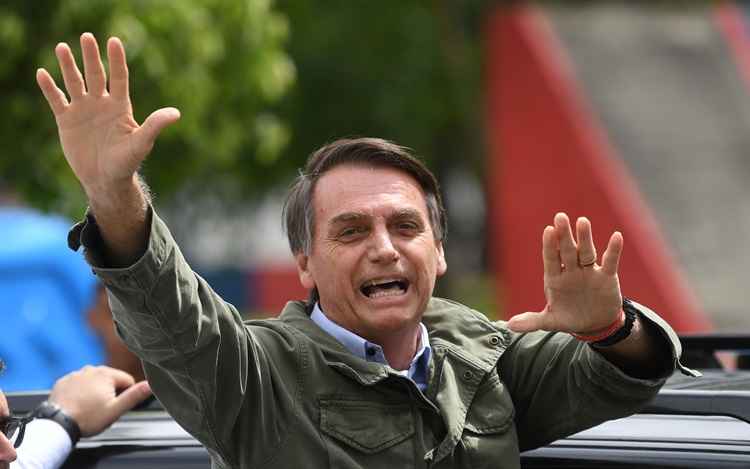 Brazil's new President Jair Bolsonaro waves to the crowd after receiving the presidential sash during his inauguration ceremony, at Planalto Palace in Brasilia on January 1, 2019. Bolsonaro takes office with promises to radically change the path taken by Latin America's biggest country by trashing decades of centre-left policies. / AFP / EVARISTO SA