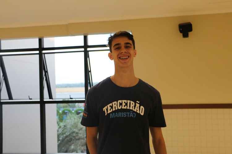 Homem branco com expressões sorridentes, usando uma camisa preta escrita %u2018Terceirão Marista%u2019