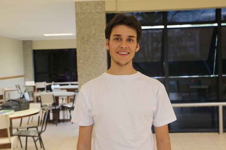 Homem branco sorrindo e usando uma blusa branca