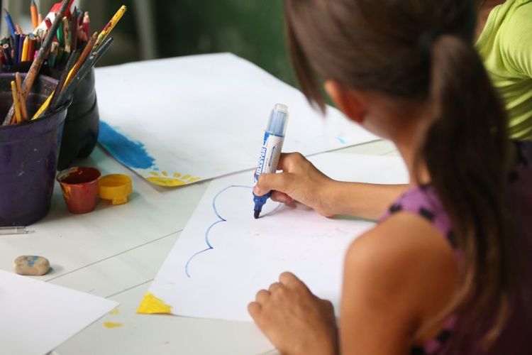 foto de menina estudando por meio de projetos sociais educativos no DF