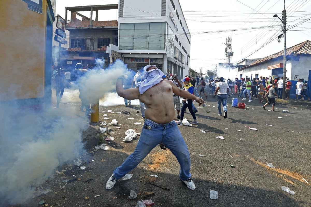 Conflito nas fronteiras da Venezuela: homem joga bomba de gás