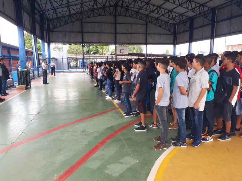 Alunos do 6º e 7º anos do ensino fundamental ficam perfilados para ouvir instruções da Polícia Militar e cantar o Hino Nacional