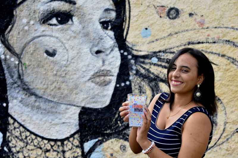 Meninas segurando copo do bloco Eduardo e Mônica