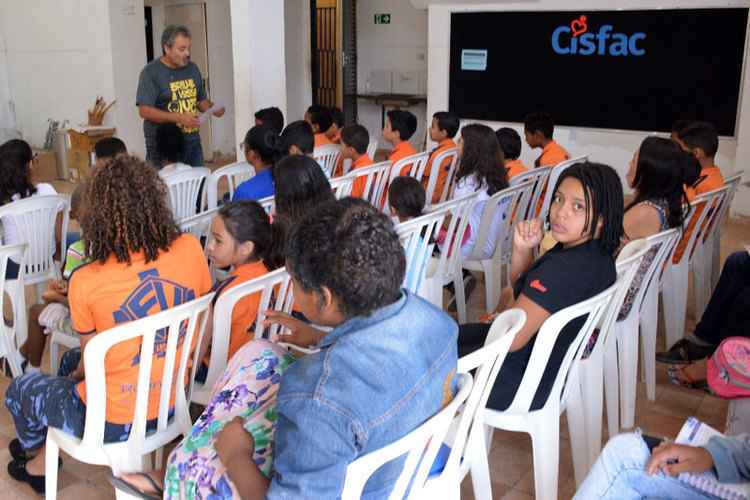 Crianças da banda sentadas tendo aula