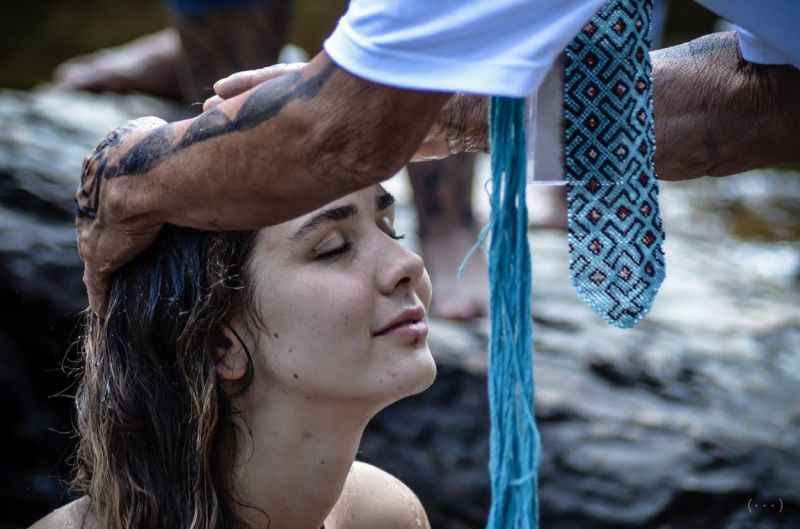 Mulher agachada e com olhos fechados durante atividade na Chapada dos Veadeiros