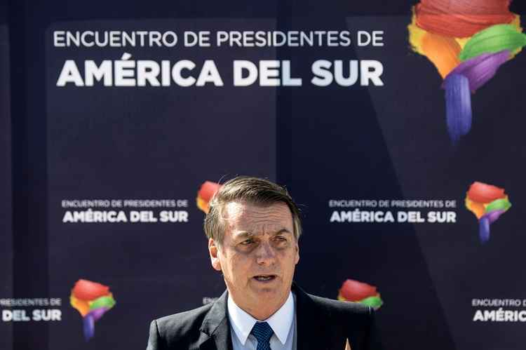 Brazil's President Jair Bolsonaro delivers a speech upon landing at Santiago's airport on March 21, 2019. Bolsonaro is in Chile on a three-day official visit. / AFP / Martin BERNETTI