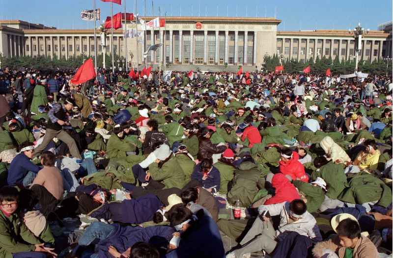 Estudantes em greve de fome se deitam na Praça Tiananmen, diante do Grande Salão do Povo, centro de poder do Partido Comunista da China