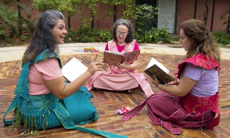 três mulheres sentadas na grama lendo livros