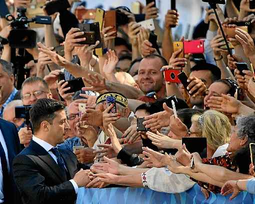 Volodymyr Zelensky cumprimenta simpatizantes na chegada à sede do Legislativo, em Kiev, para  a cerimônia de posse: reviravolta política