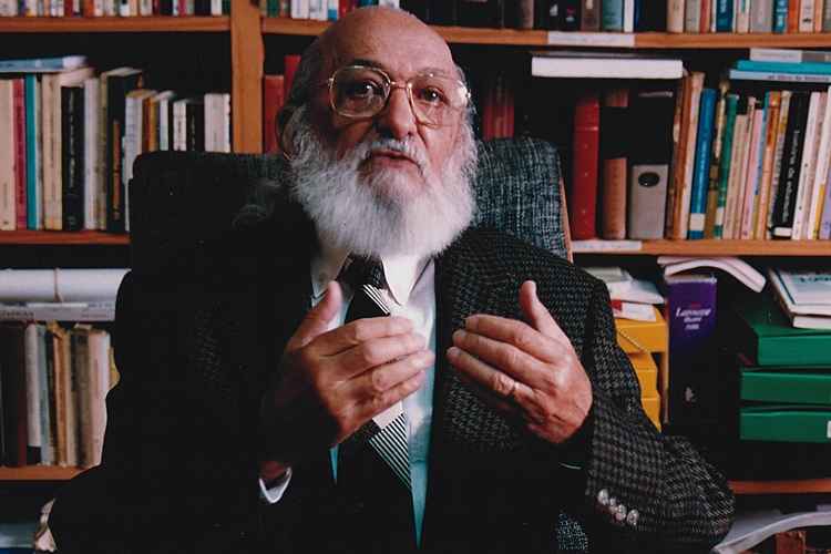 Paulo Freire sentado em uma cadeira