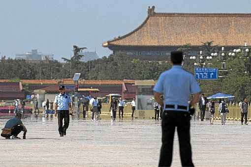 Policiais patrulham a Praça Tiananmen, diante do Grande Portão que permite acessar a Cidade Proibida: vigilância rígida para coibir manifestações