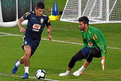 Firmino e Alisson durante treino no Pacaembu: equipe estreia na sexta-feira contra a Bolívia