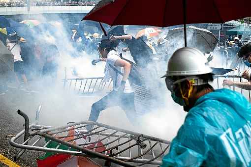 Manifestantes correm em meio à repressão das forças de segurança nas imediações do quartel-general do governo de Hong Kong: risco de caos