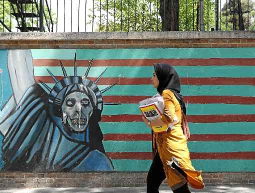 Moradora de Teerã caminha diante de grafite com referência à Estátua da Liberdade, em muro da Embaixada dos Estados Unidos: tensão crescente