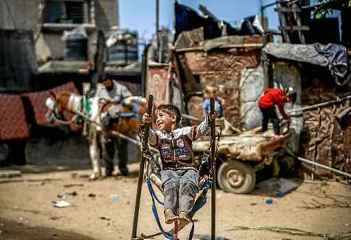 Garoto brinca com balanço improvisado, em Beit Lahia, na Faixa de Gaza