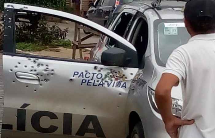 carro da policia perfurado de tiros com a porta aberta