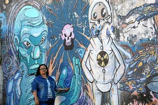 Célia Helena Vasconcelos em frente ao grafite que inspirou a pesquisa sobre a tragédia em Goiânia: 