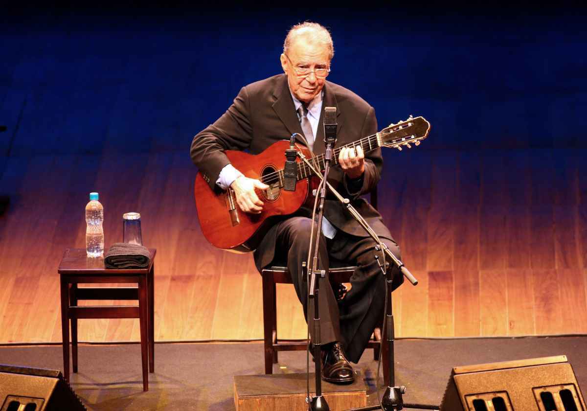 João Gilberto toca um violão em um show