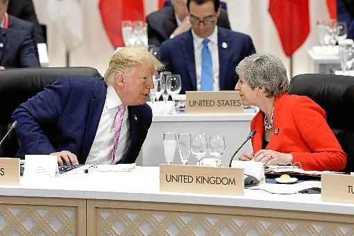 Donald Trump e Theresa May conversam na reunião do G20, em Osaka, no mês passado: Londres investiga o episódio