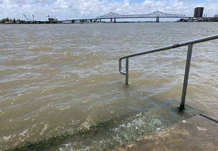 O rio Mississippi bate nas escadas em um dique de proteção em Nova Orleans