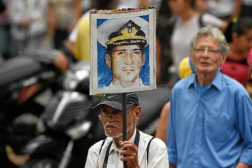 Manifestante carrega placa com a foto de Rafael Acosta: morte na prisão