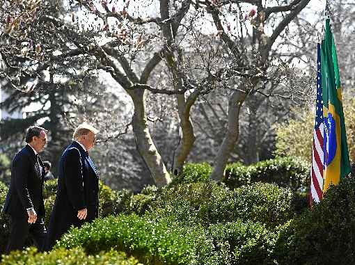 Bolsonaro e Trump caminham pelos jardins da Casa Branca, em março