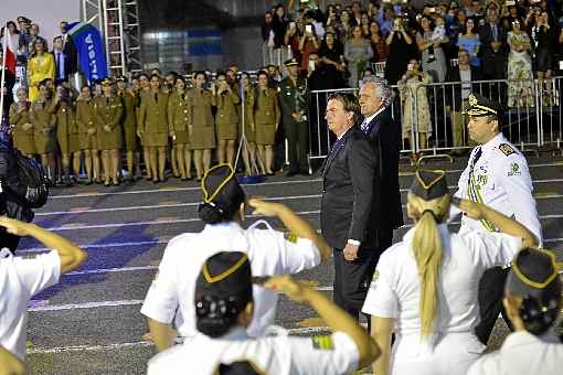 Bolsonaro passa as tropas em revista, acompanhado de Ronaldo Caiado, durante solenidade da Polícia Militar goiana: elogios mútuos, críticas ao PT e condecoração