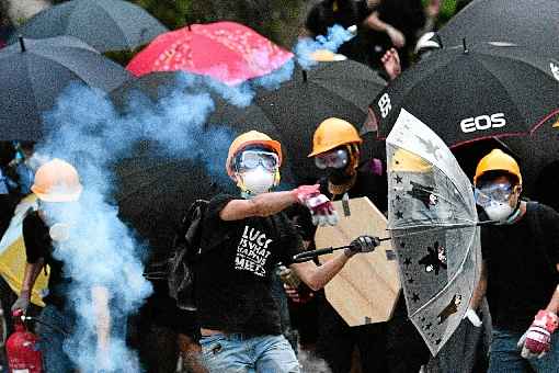 Ativista pró-democracia atira de volta bomba de gás lançada pela tropa