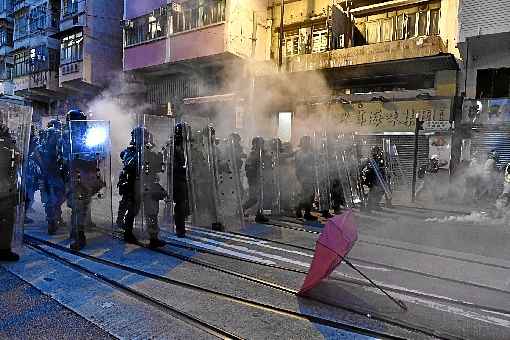 Policiais lançam gás lacrimogêneo contra manifestantes, na noite de domingo: iniciadas em junho, marchas fogem do controle das forças de segurança