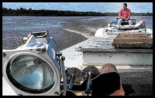 Com a arma no colo, segurança da fronteira peruana atira para cima toda vez que passa por algum ponto considerado perigoso do rio. É uma tentativa de evitar ataques de criminosos