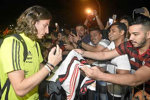 Filipe Luís atende os torcedores na chegada do Flamengo ao hotel: responsabilidade de manter sequência vitoriosa