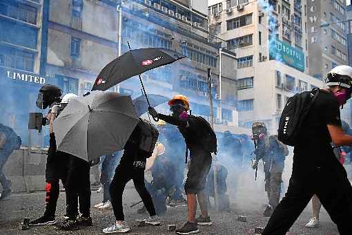 Ativistas se protegem com guarda-chuvas para evitar intoxicação pelas granadas de gás: fim da calmaria após 10 dias