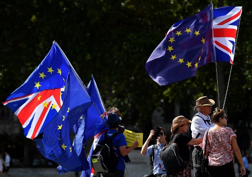 Ativistas anti-Brexit seguram bandeiras da União e da UE enquanto se manifestam em frente às Casas do Parlamento em Westminster, em Londres.