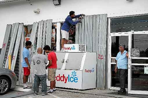 Homens instalam proteção em vitrine de um mercado em Riviera Beach: Casa Branca pede vigilância máxima