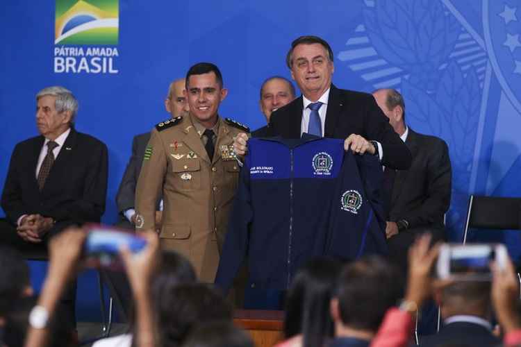 Bolsonaro segura um uniforme de escola militar