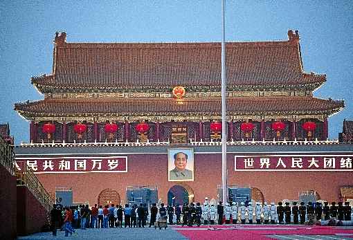 Membros da Guarda de Honra recolhem o pavilhão nacional, na Praça Tiananmen (