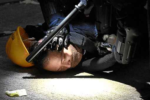 Repressão a protestos na ex-colônia britânica ofusca o 70º aniversário do regime comunista, celebrado com desfile militar e com discurso de Xi Jinping em Pequim. Policial dispara contra peito de manifestante, no primeiro uso de munição letal em quatro meses de crise