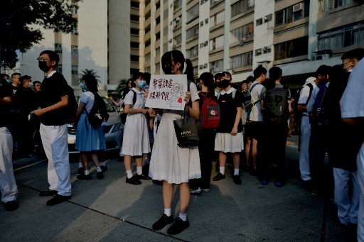 Protesto em frente à escola de Tsang Chi-kin, onde um jovem foi ferido após confronto com a polícia de Hong Kong