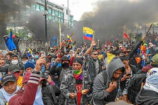 Manifestantes enfrentam as forças de segurança diante do Congresso, em Quito: capital em convulsão, com estado de exceção e toque de recolher