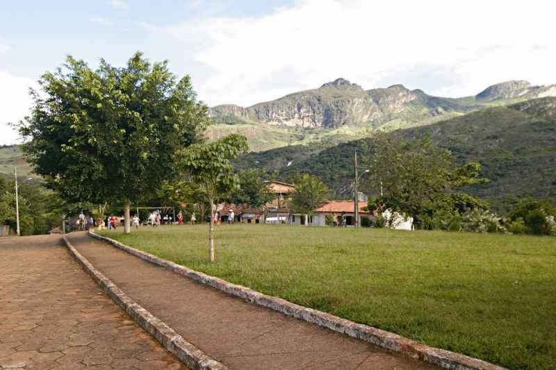 Montanhas e pasto verde com casas ao fundo