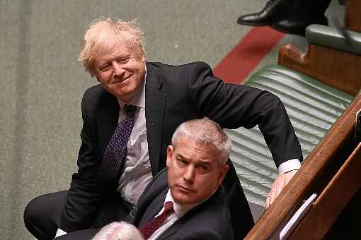 Ao lado do ministro do Brexit, Stephen Barclay (E), o premiê sorri durante a votação do acordo com Bruxelas no Parlamento: calendário acelerado