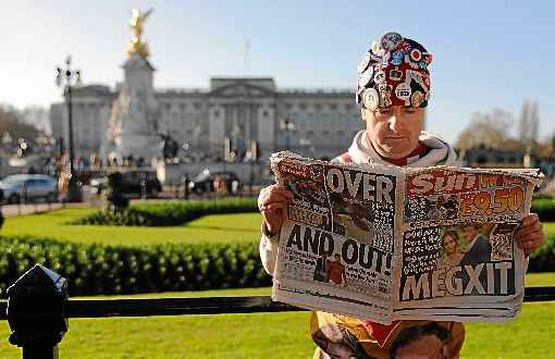 Em frente ao PalÃ¡cio de Buckingham, britÃ¢nico lÃª notÃ­cias sobre o %u201CMegxit%u201D: Elizabeth II estÃ¡ decepcionada