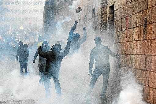 Manifestantes jogam pedras em direÃ§Ã£o Ã  sede da Prefeitura de Paris, em meio ao gÃ¡s lacrimogÃªneo