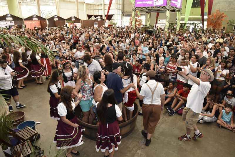 Pessoas pisando em uvas para fazer vinho em galpÃ£o de festa